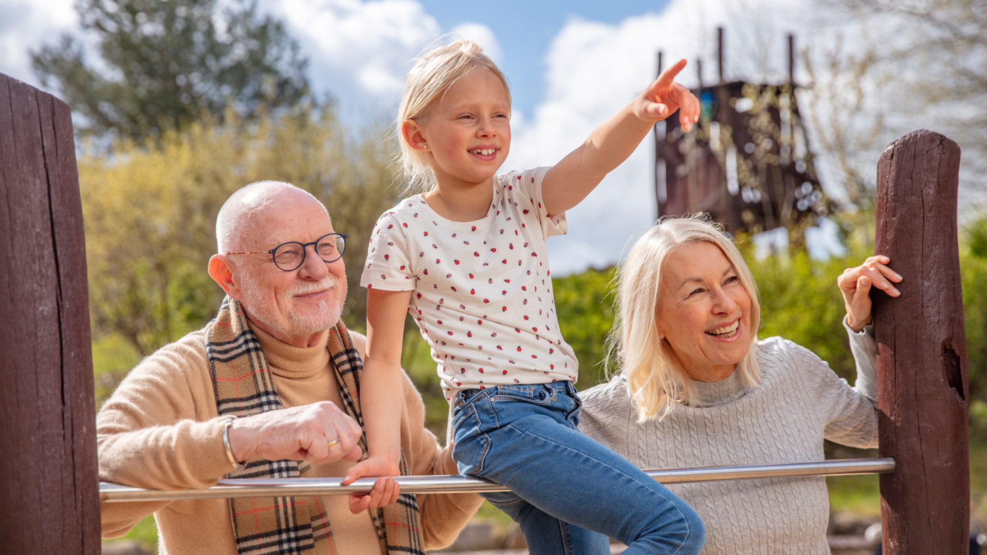 Enkeln mit Großeltern auf dem Spielplatz während Urlaub im Familienresort in MV