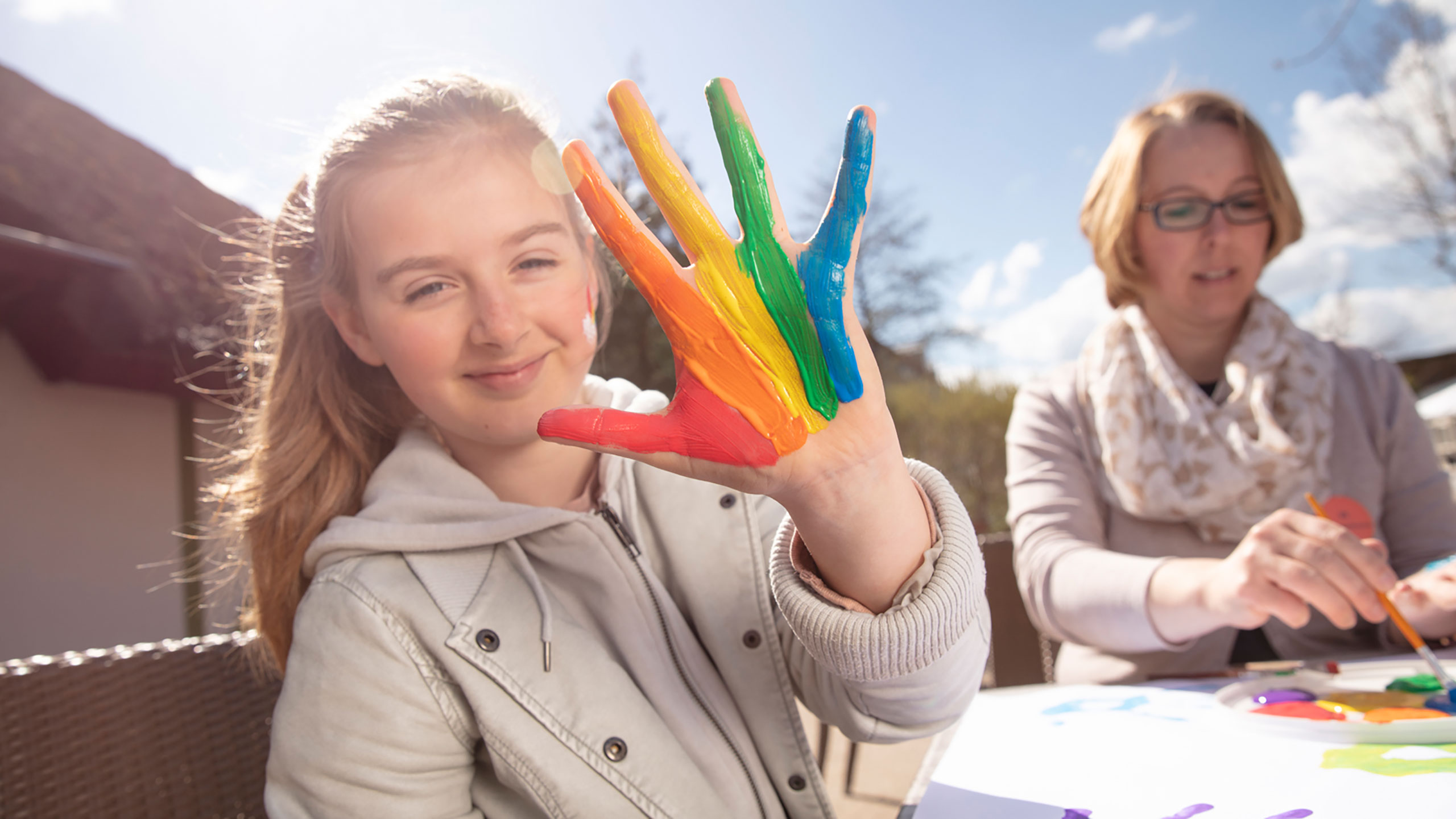 Kind mit Fingerfarben an der Hand in der Kinderbetreuung