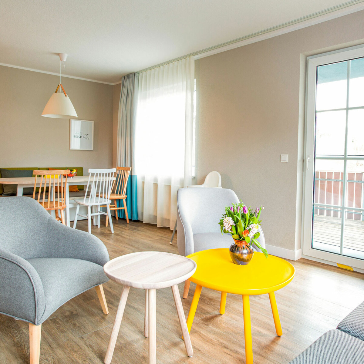 Blick in den hellen Wohnbereich einer Ferienwohnung für Familien am Fleesensee