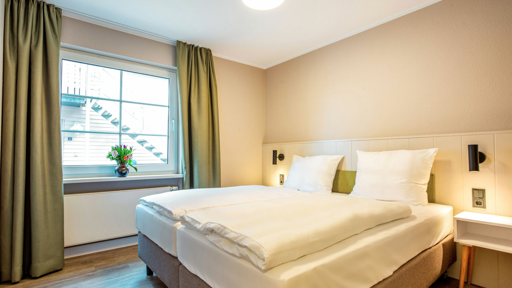 Helles Schlafzimmer mit Doppelbett in der Ferienwohnung am Fleesensee