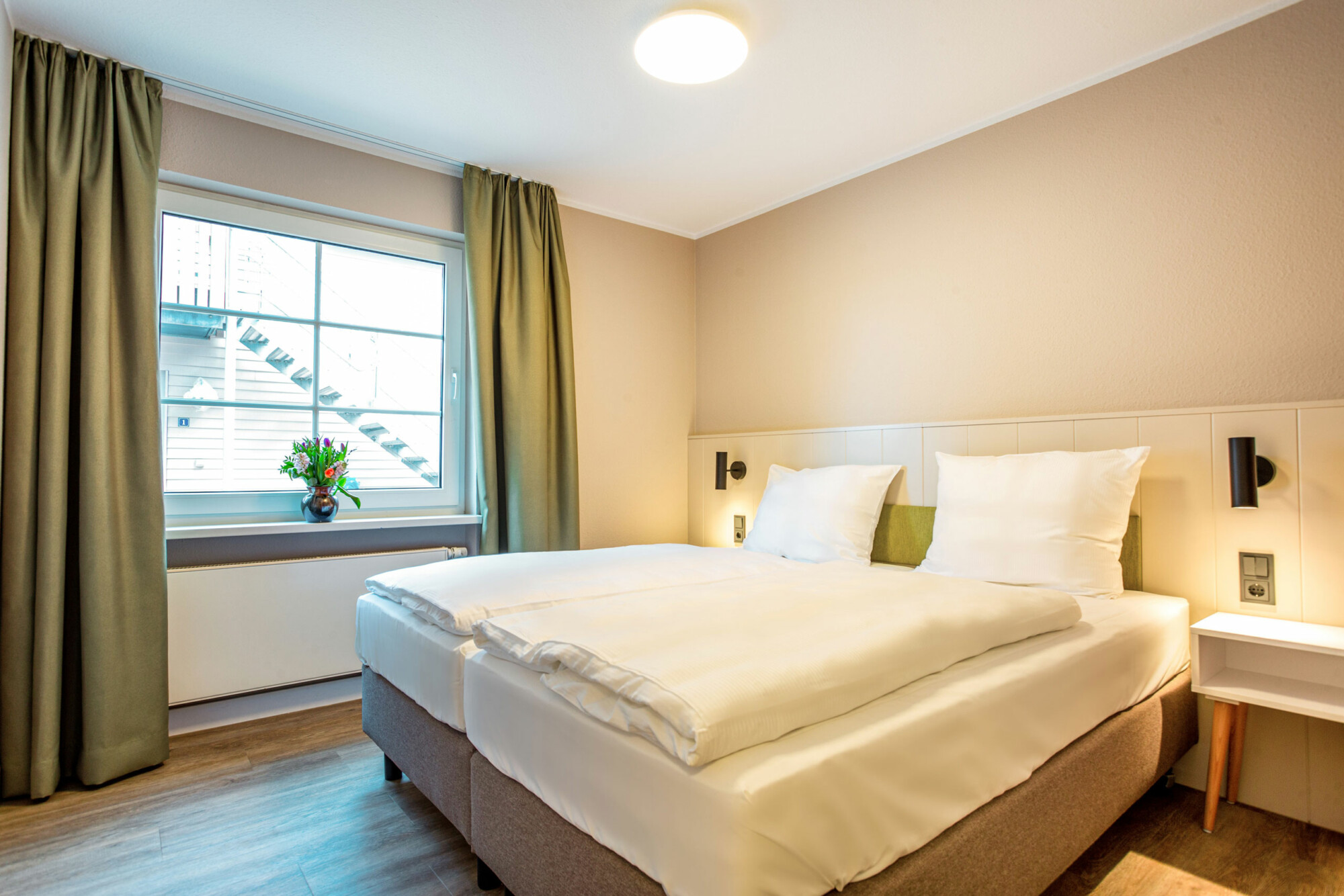Helles Schlafzimmer mit Doppelbett in der Ferienwohnung am Fleesensee
