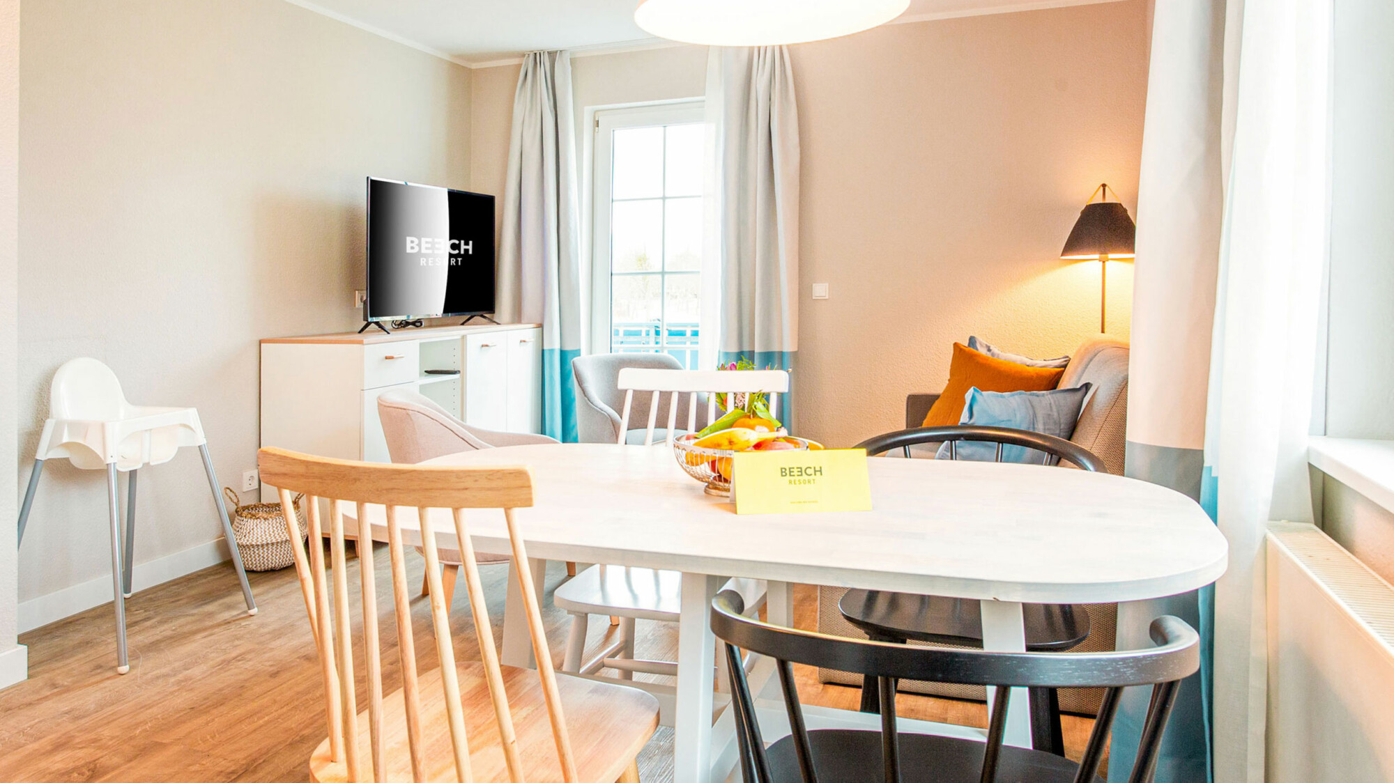 Wohnbereich eines kinderfreundlichen Ferienapartments mit Esstisch und Schlafcouch