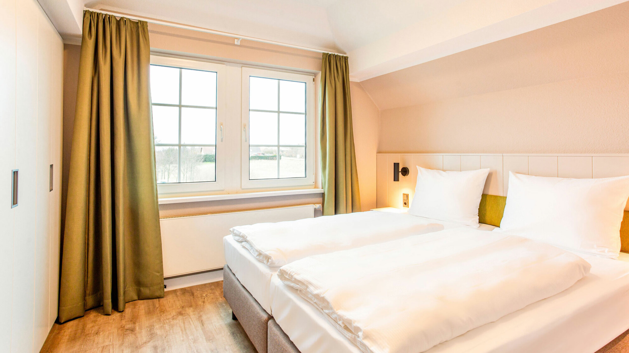 Gemütliches Doppelbett im Schlafzimmer eines Ferienapartments am Fleesensee