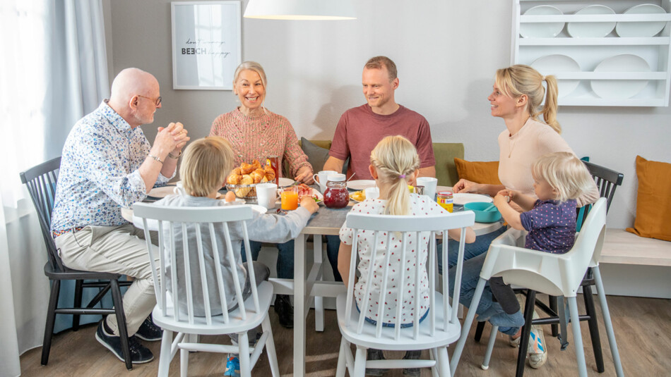 Familie sitzt am Esstisch im Apartment am Fleesensee