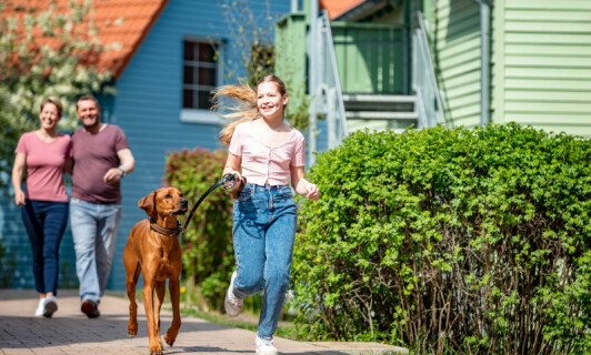 Kind läuft mit Hund im BEECH Resort Fleesensee | Urlaub mit Hund