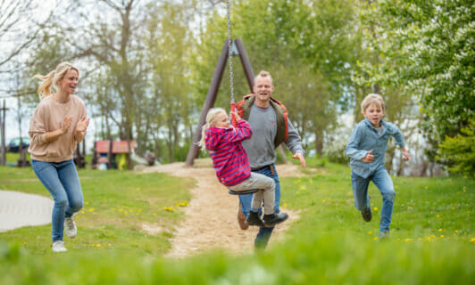 Familie läuft auf dem Spielplatz mit der Zipline