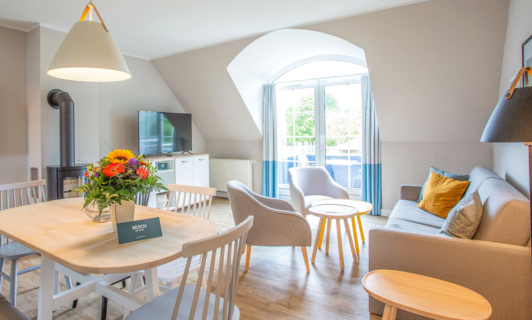 Heller Wohnbereich eines BEECH Apartments mit Esstisch