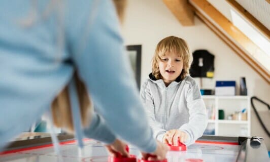 Kind spielt Tisch Curling im Familienhotel in Mecklenburg Vorpommern