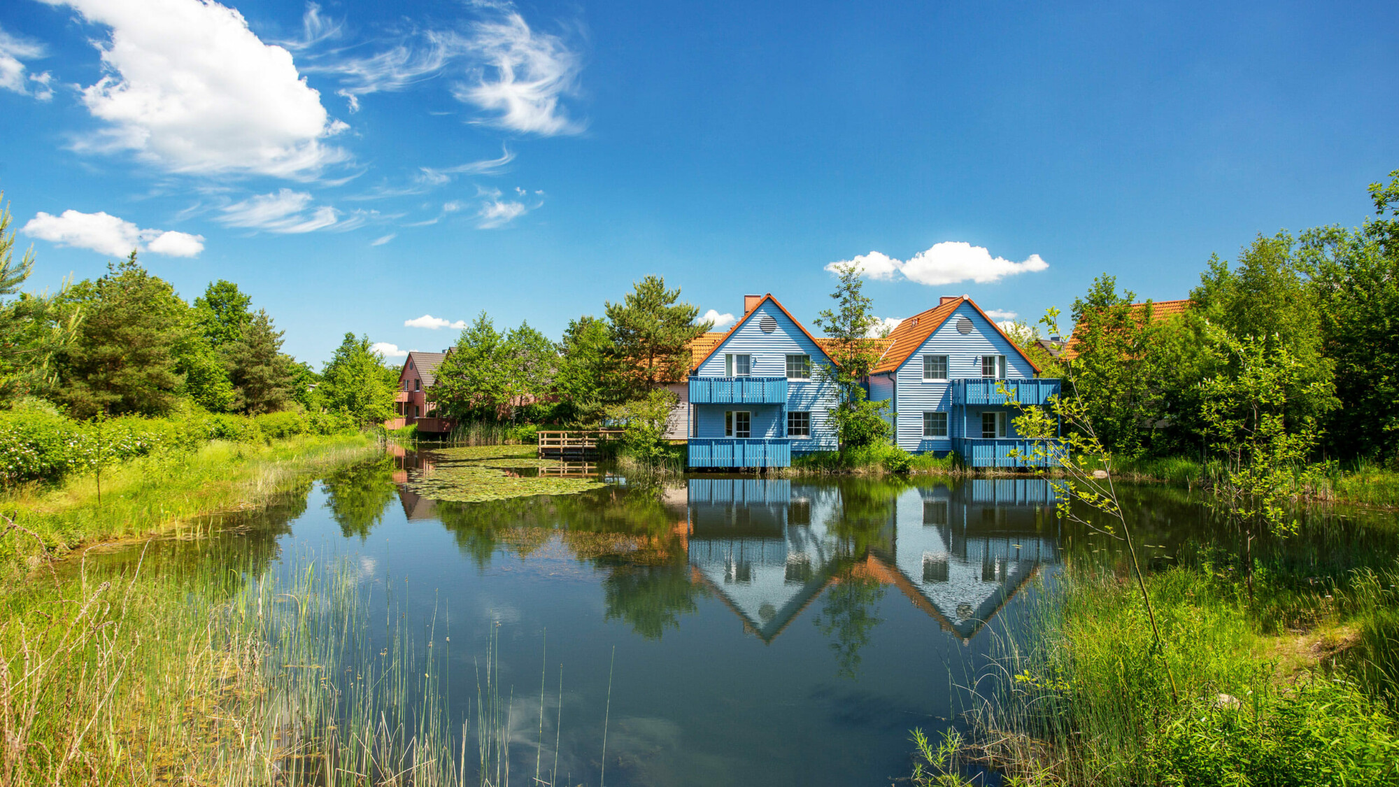 Zwei blaue Appartmenthäuser für Urlaub mit Kindern direkt am See