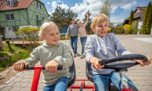 Geschwister erkunden mit dem Kettcar durch Familienresort in Mecklenburg Vorpommern