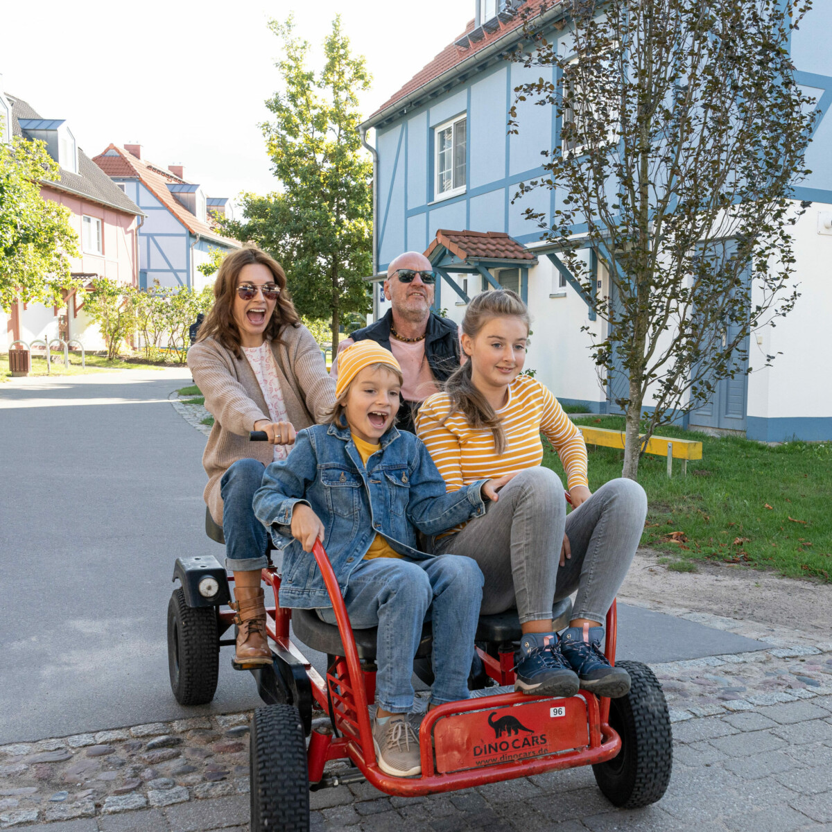Familie fährt durch Familienresort in MV mit dem Kettcar