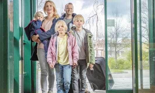 Familie kommt durch den Eingangsbereich des BEECH Resort Fleesensee für ihren Familienurlaub