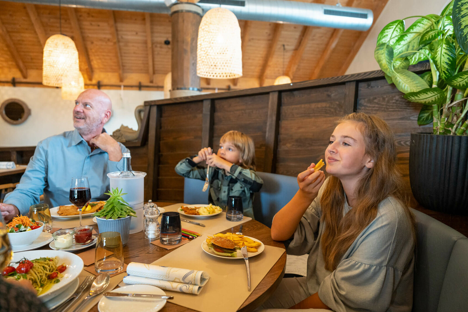 Zwei Kinder und ein Papa am Tisch im Restaurant