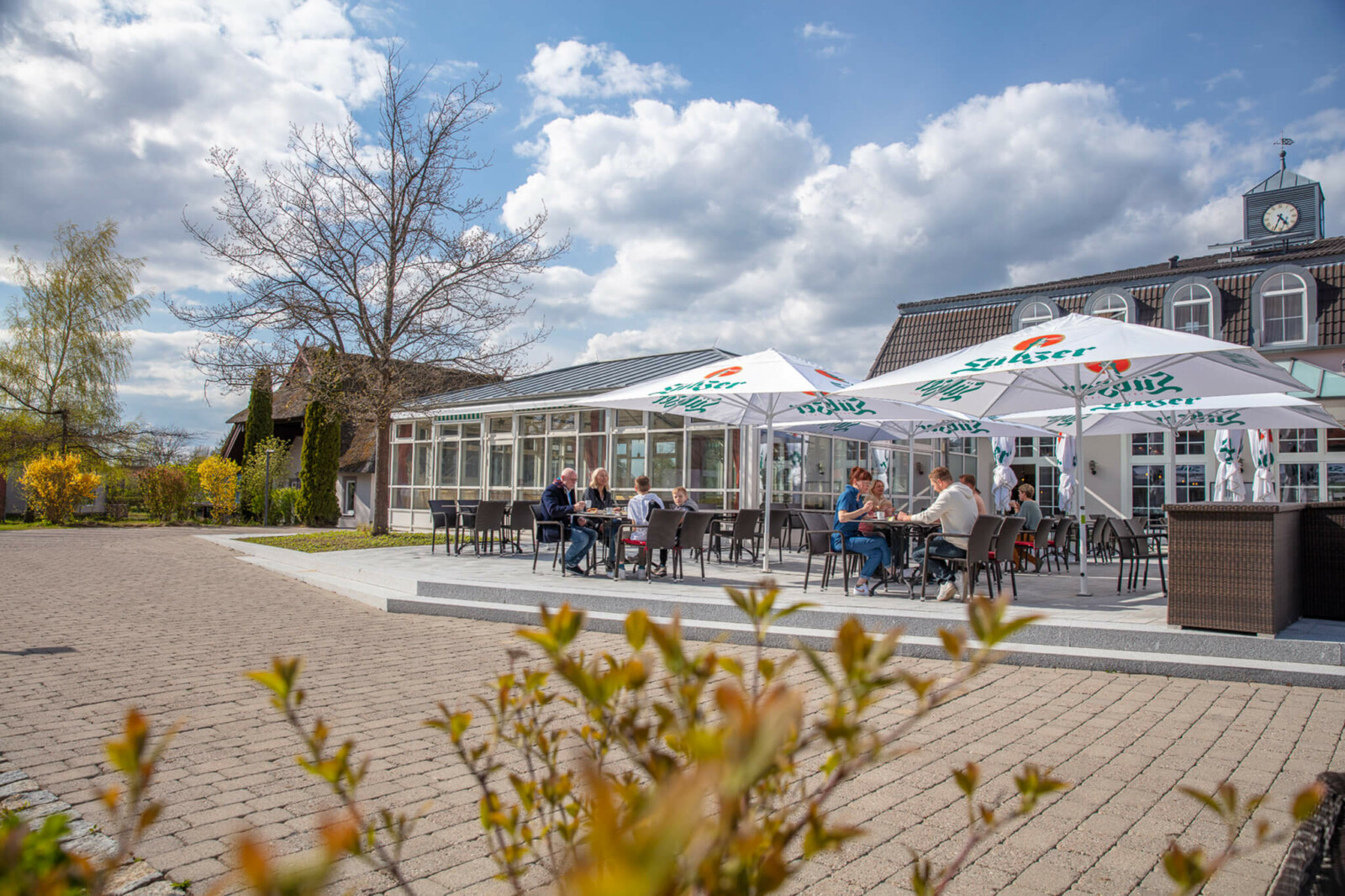 Terrasse auf der Menschen an Tischen sitzen und essen